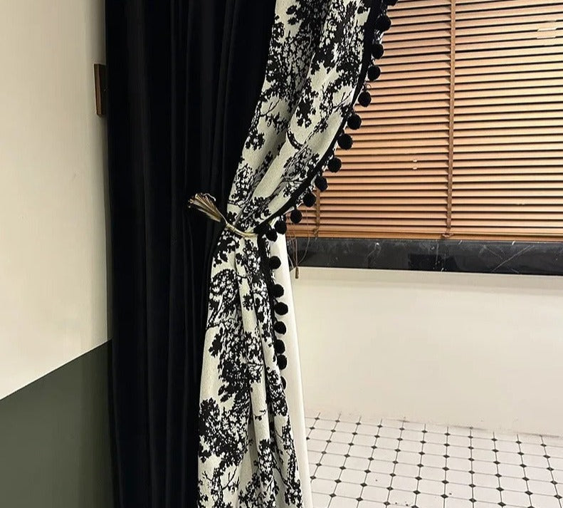 a black and white curtain with pom pom trim