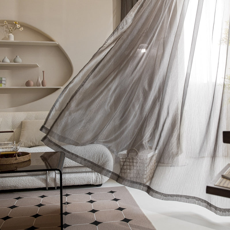 a living room filled with furniture and a sheer curtain