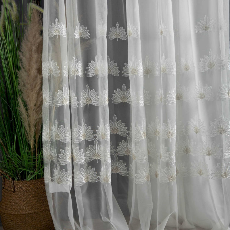 a close up of a curtain with a plant in the background