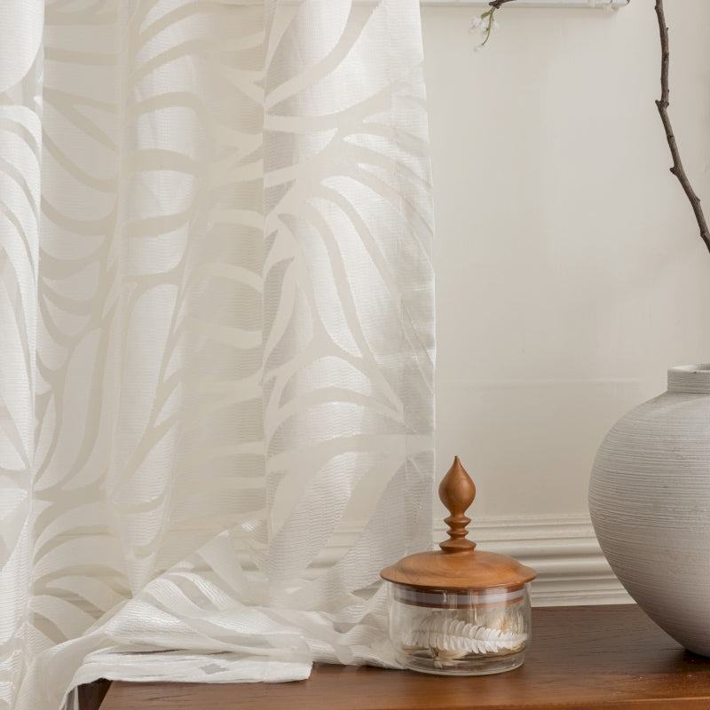 a white vase sitting on top of a wooden table