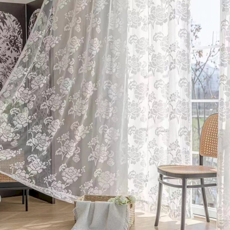 a living room with a chair and a curtain