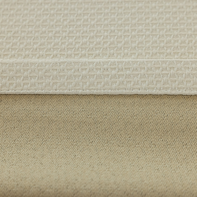 a close up of a bed with a beige cover