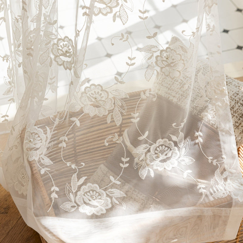 a close up of a sheer curtain with flowers on it