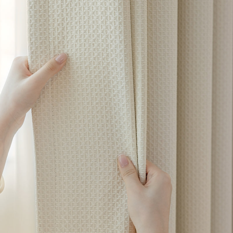 a person holding a curtain with their hands
