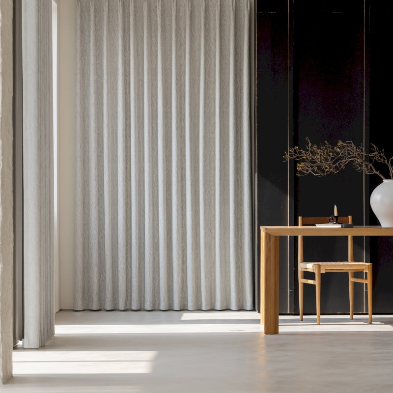 a room with a table, chair and a vase