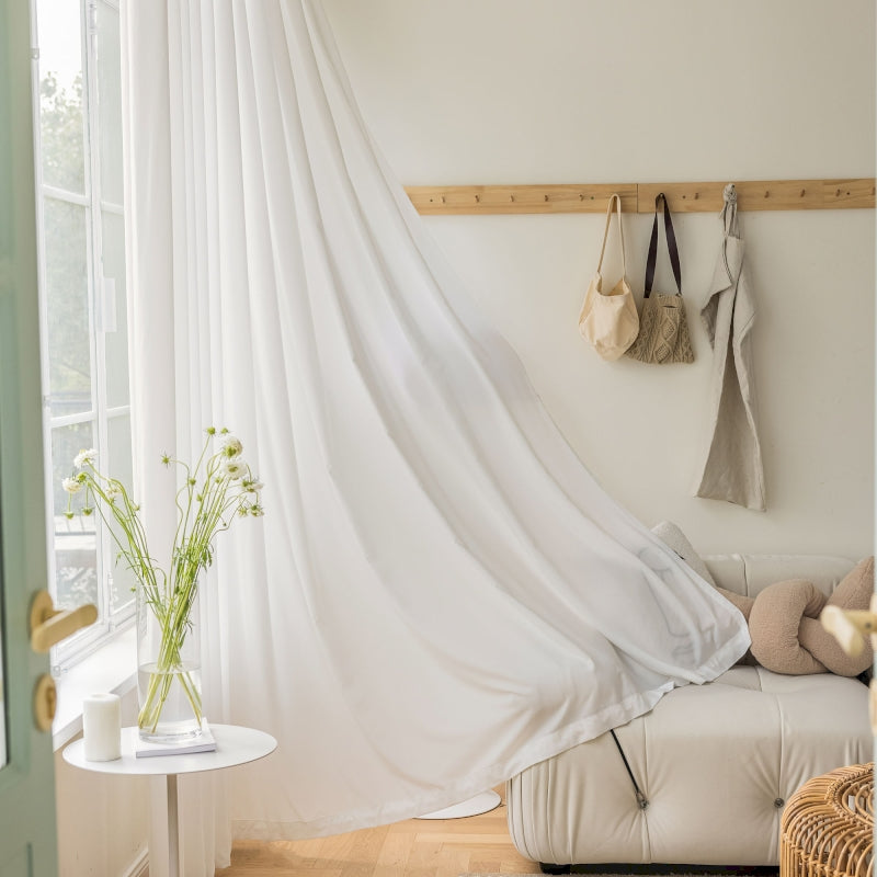 a living room with a white couch and a white curtain