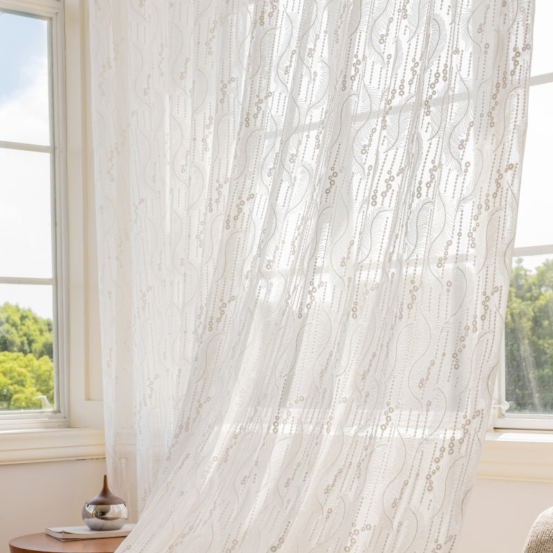 a window with a white curtain and a chair in front of it
