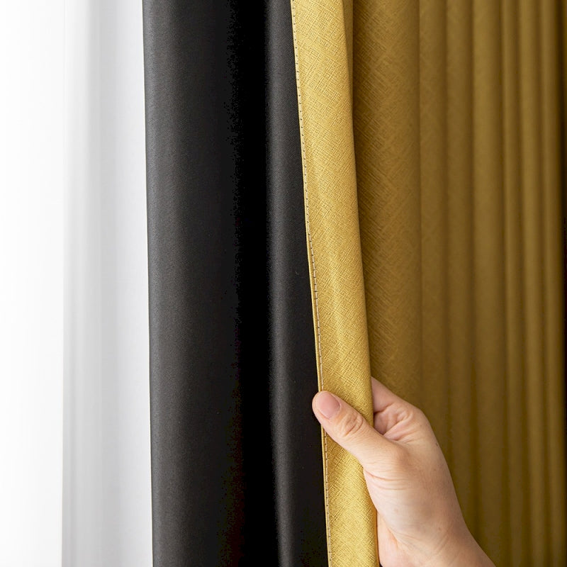 a hand holding a curtain with a black and yellow color