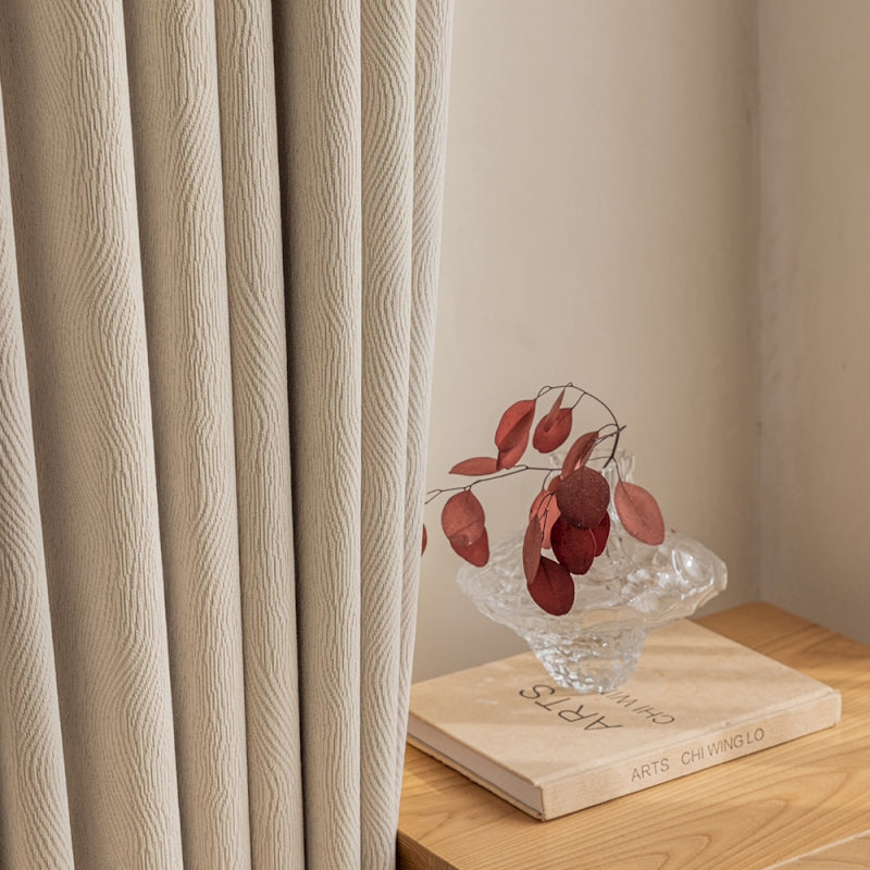 a glass vase with red flowers on top of a wooden table