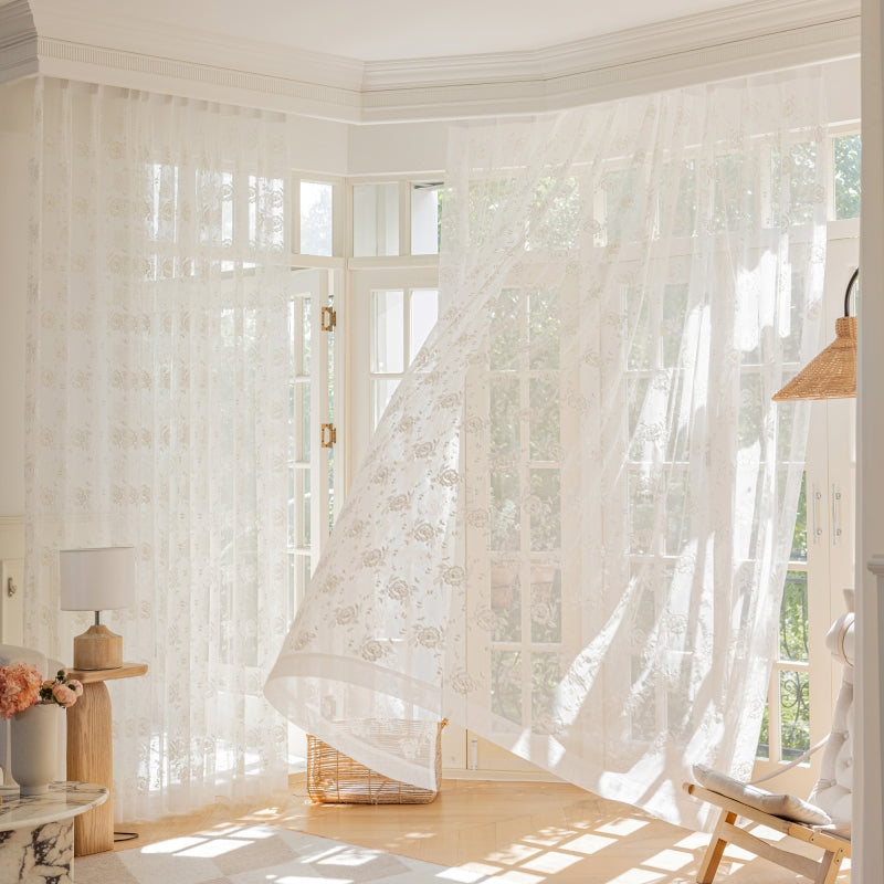 a room with a white curtain and a chair