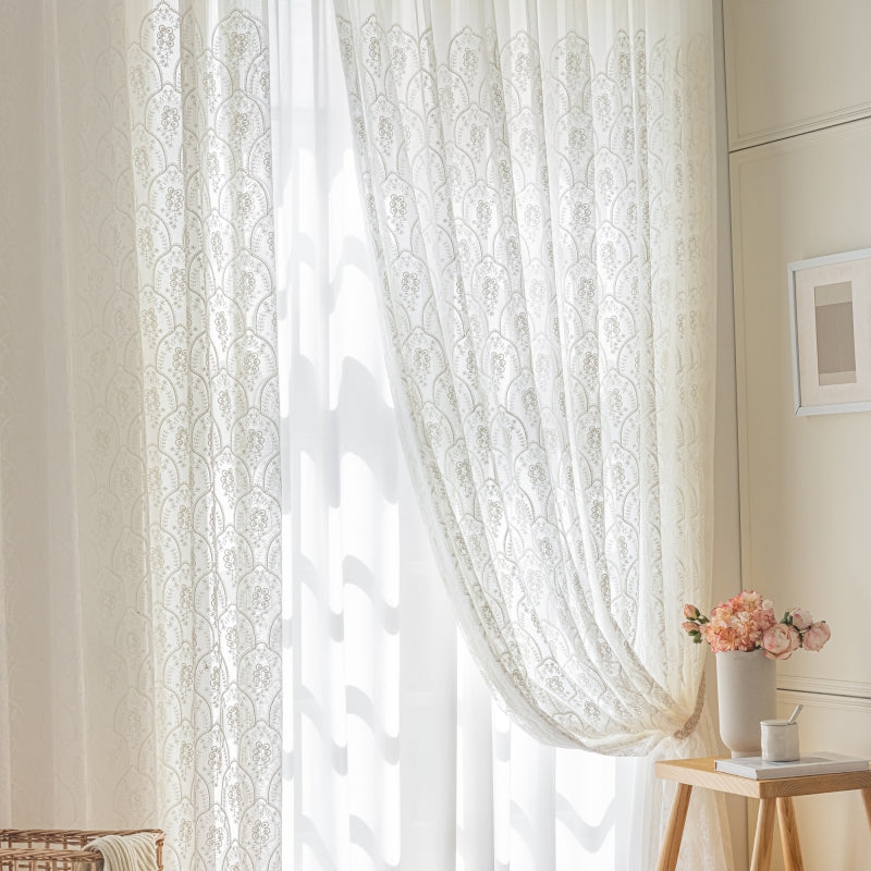 a window with a white curtain and a basket of flowers