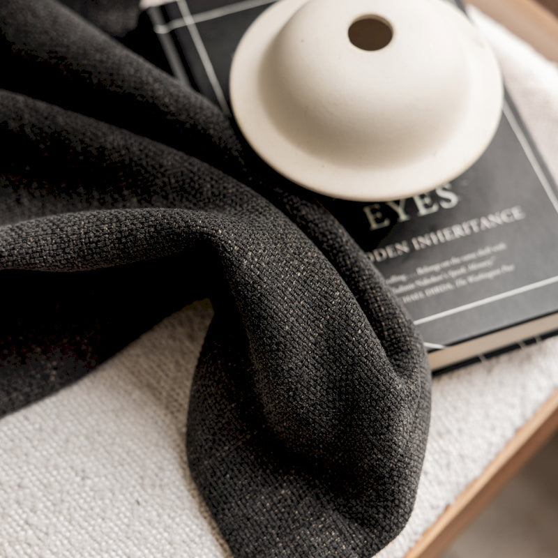 a black scarf and a white button on a table