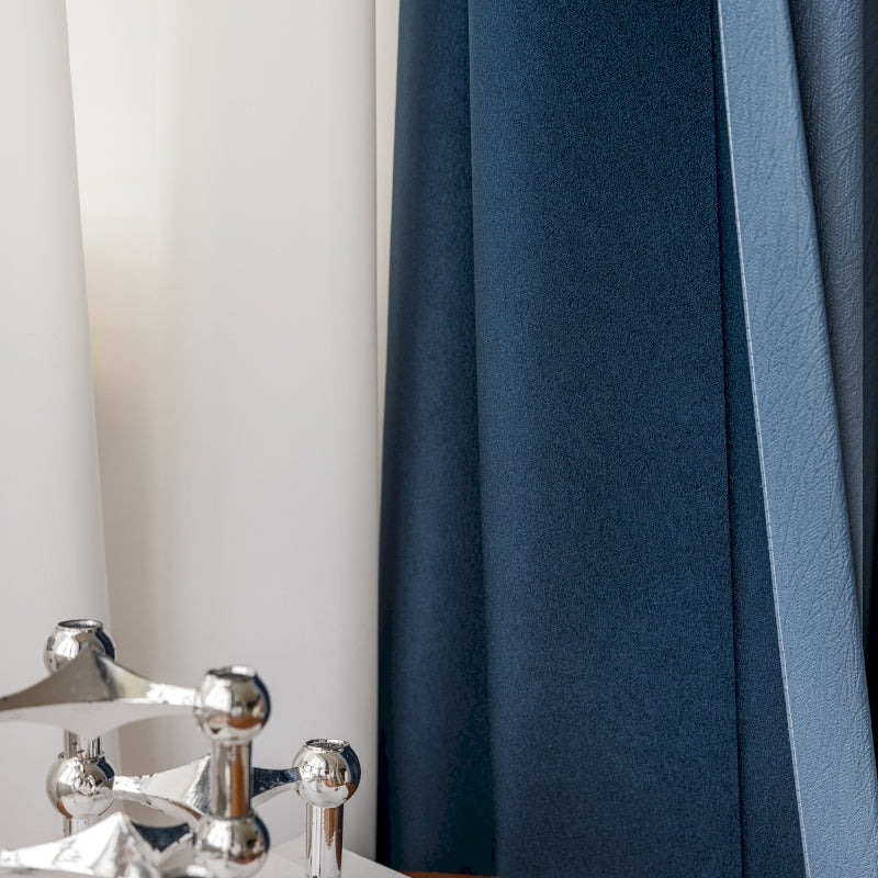 a close up of a faucet with a curtain in the background