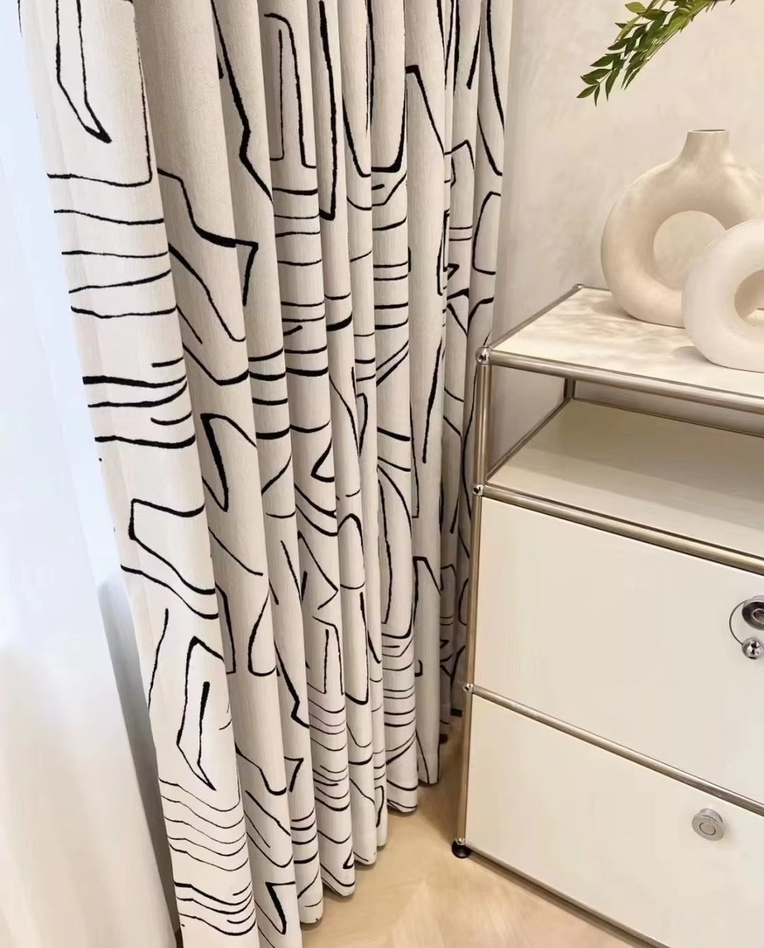 a white dresser sitting next to a window covered in curtains