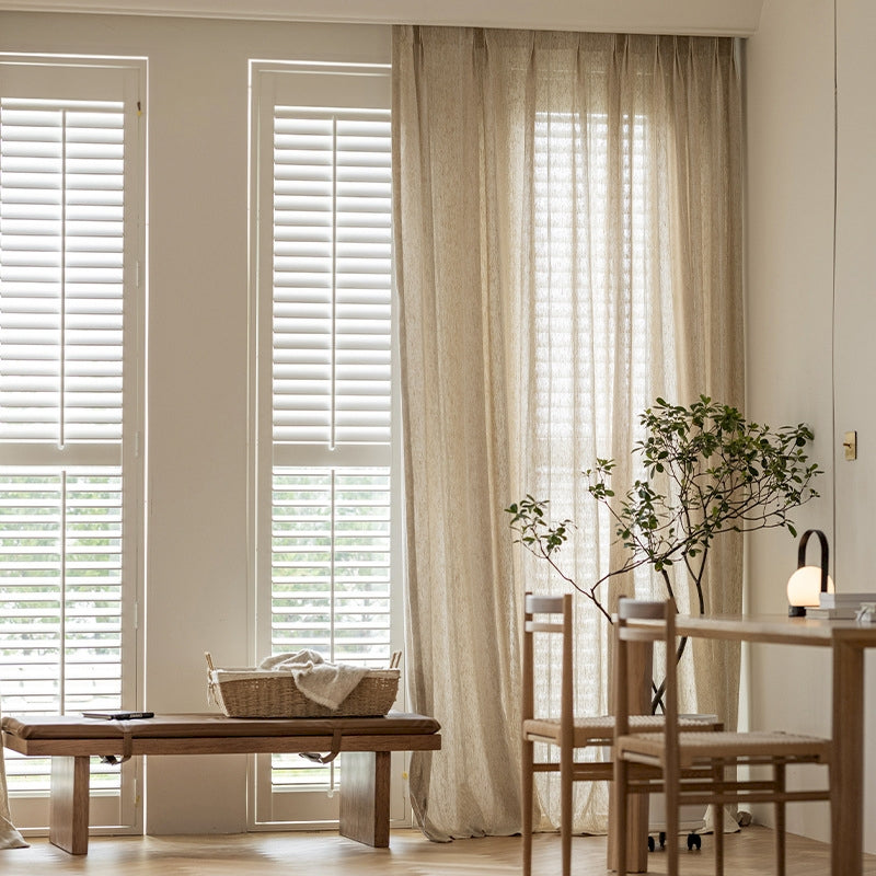 a living room filled with furniture and a window covered in blinds