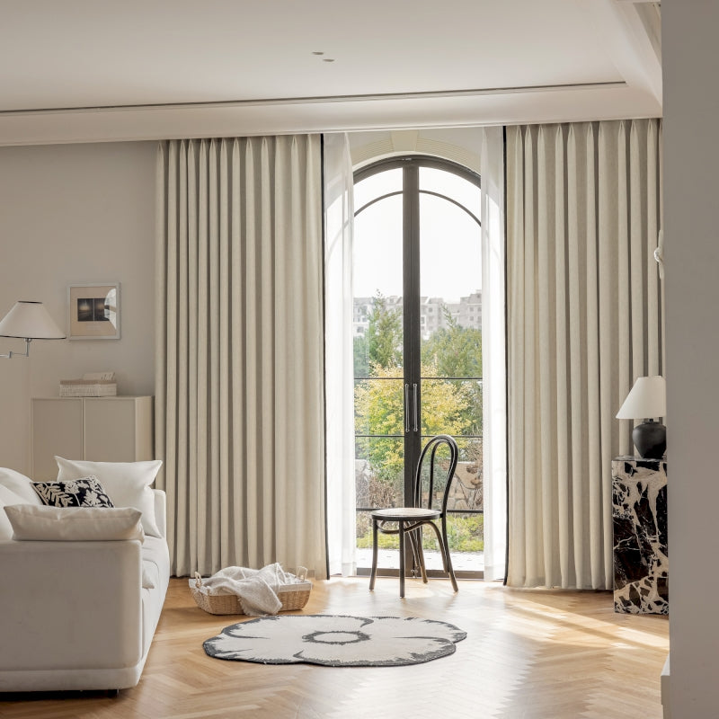 a living room with a white couch a chair and a window