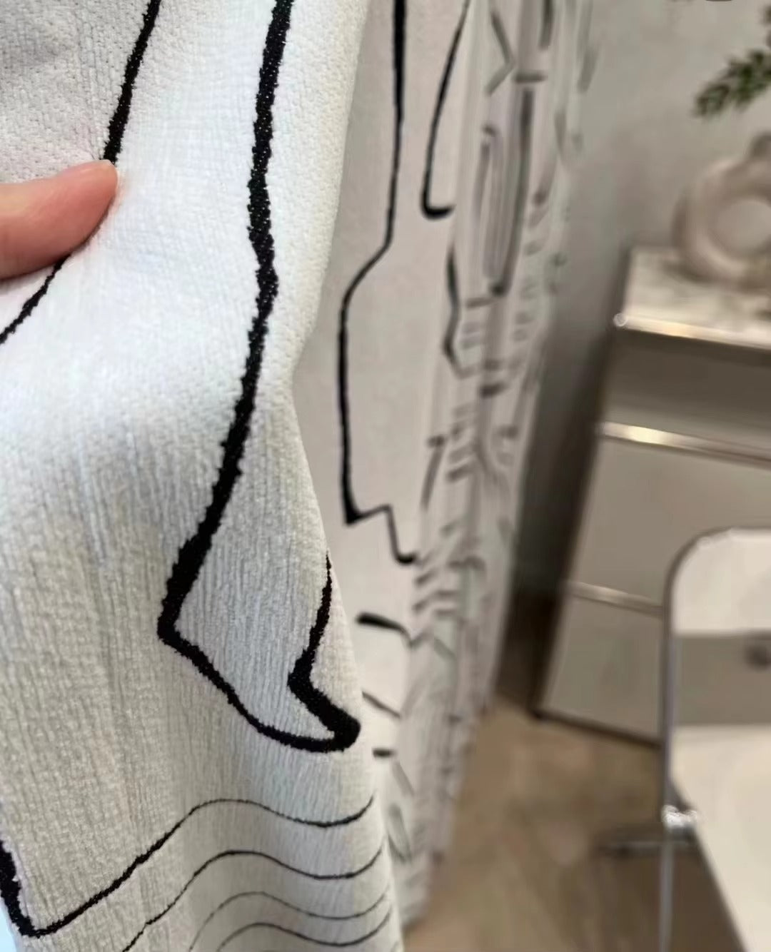 a person is holding a shower curtain in a bathroom