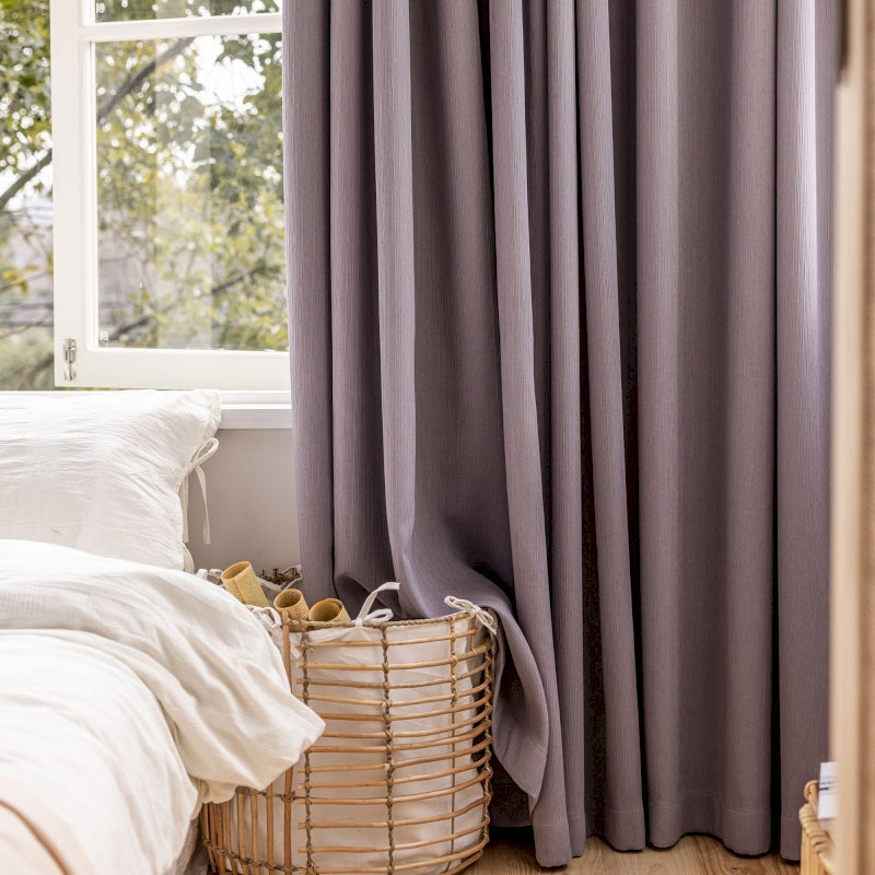 a bedroom with a bed, a basket, and a window