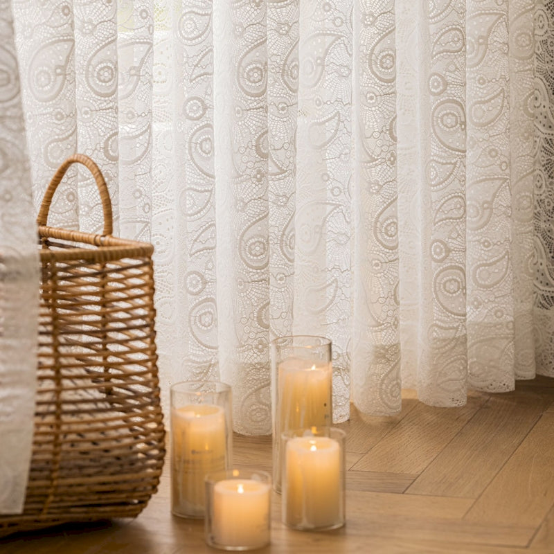 a group of candles sitting on a wooden floor next to a window