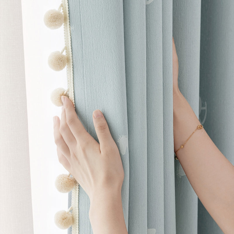 a woman's hand on the curtain of a window