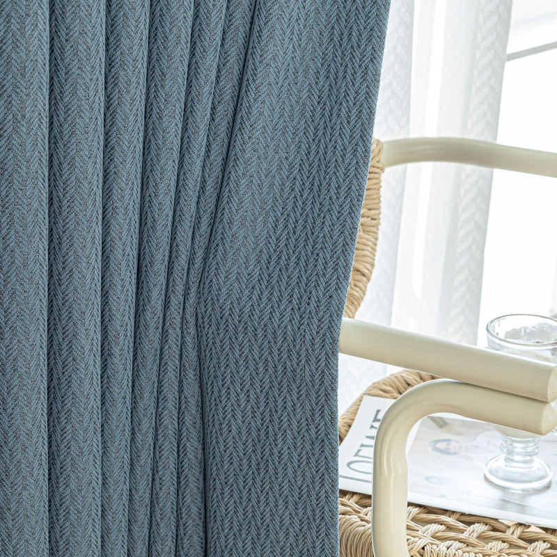 a close up of a curtain with a chair in the background