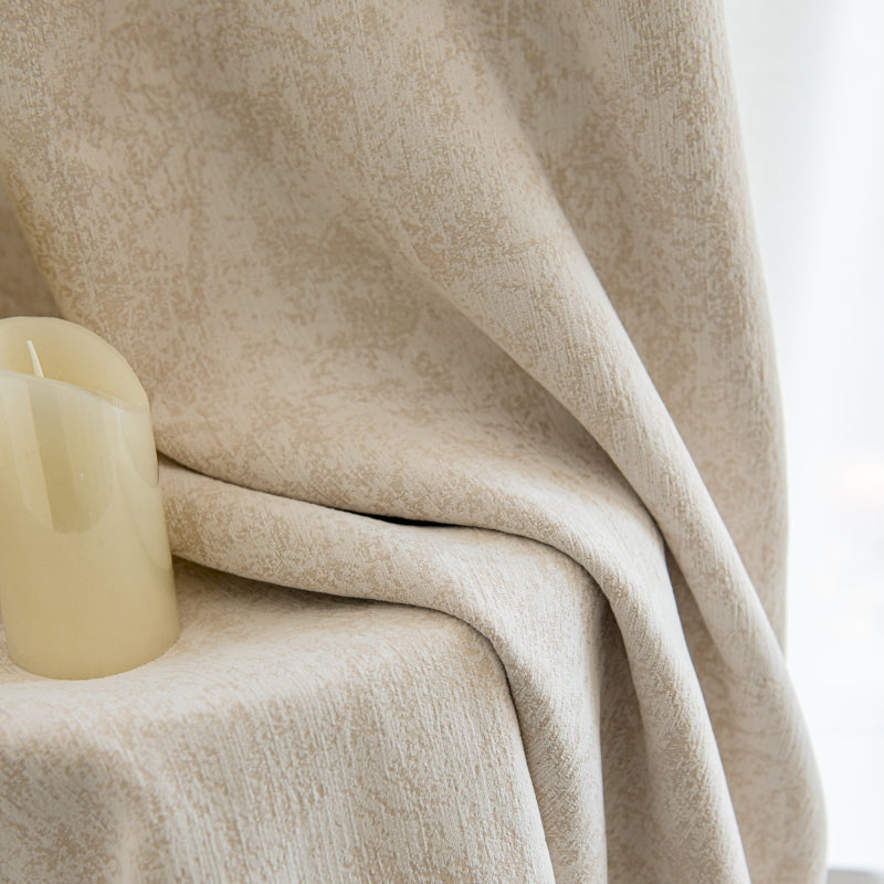 a candle sitting on top of a table under a blanket