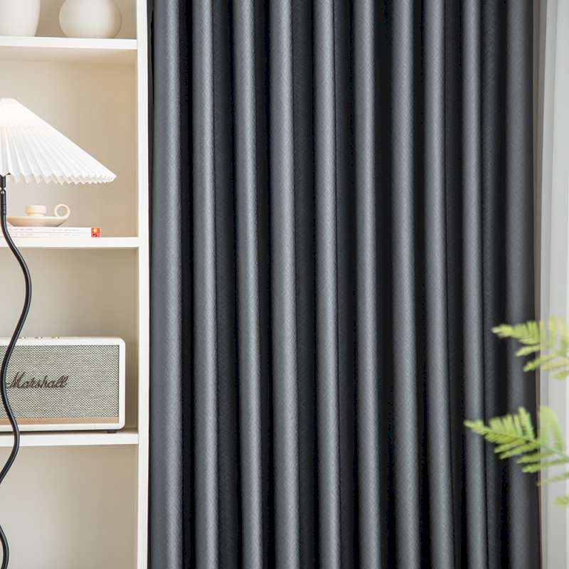 a living room with a book shelf and a black curtain