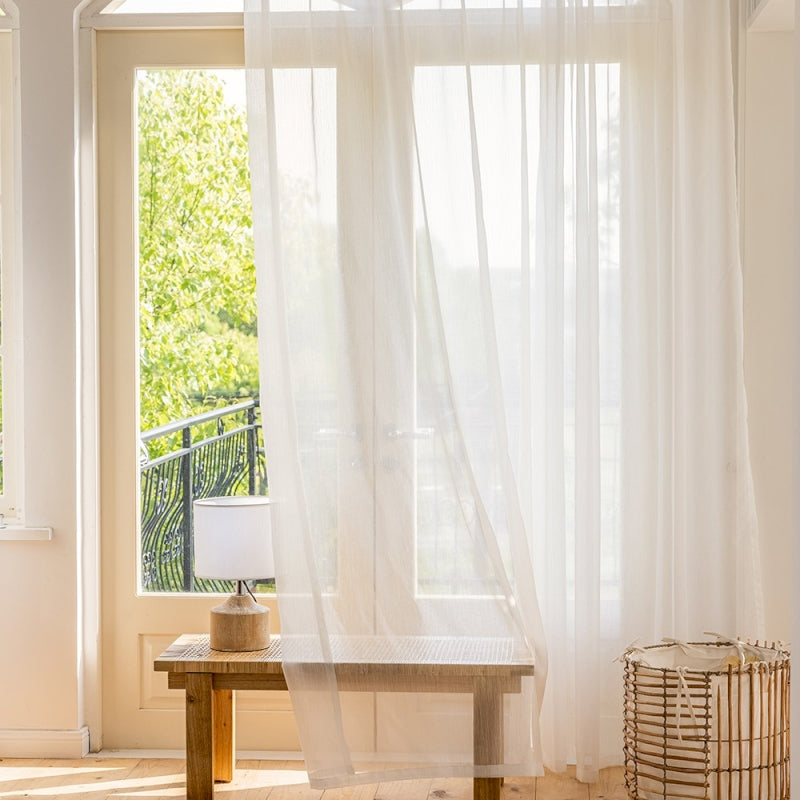 a room with a table and a white curtain