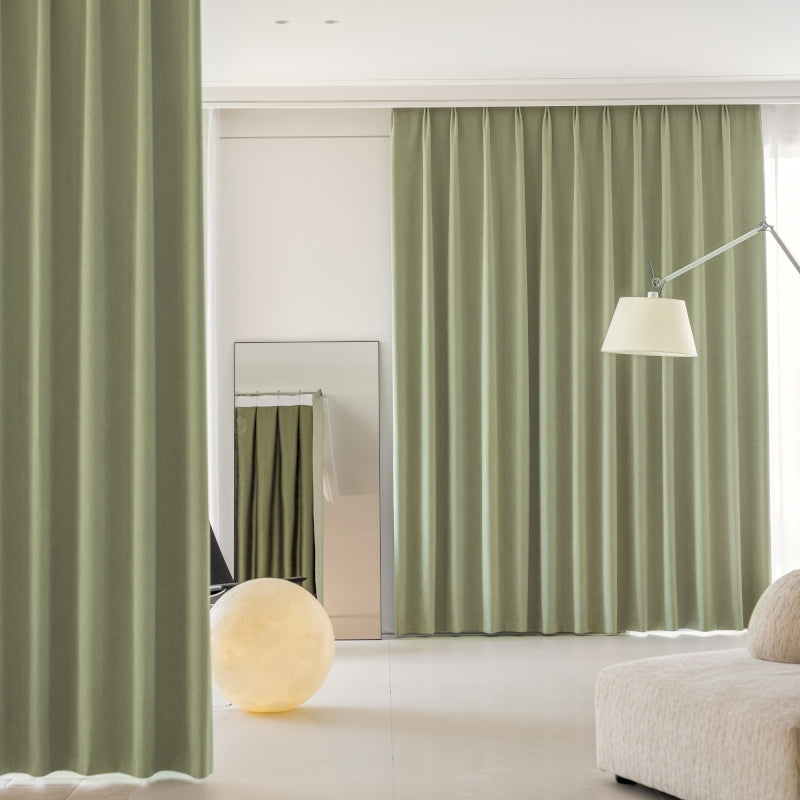 a living room with green curtains and a white couch