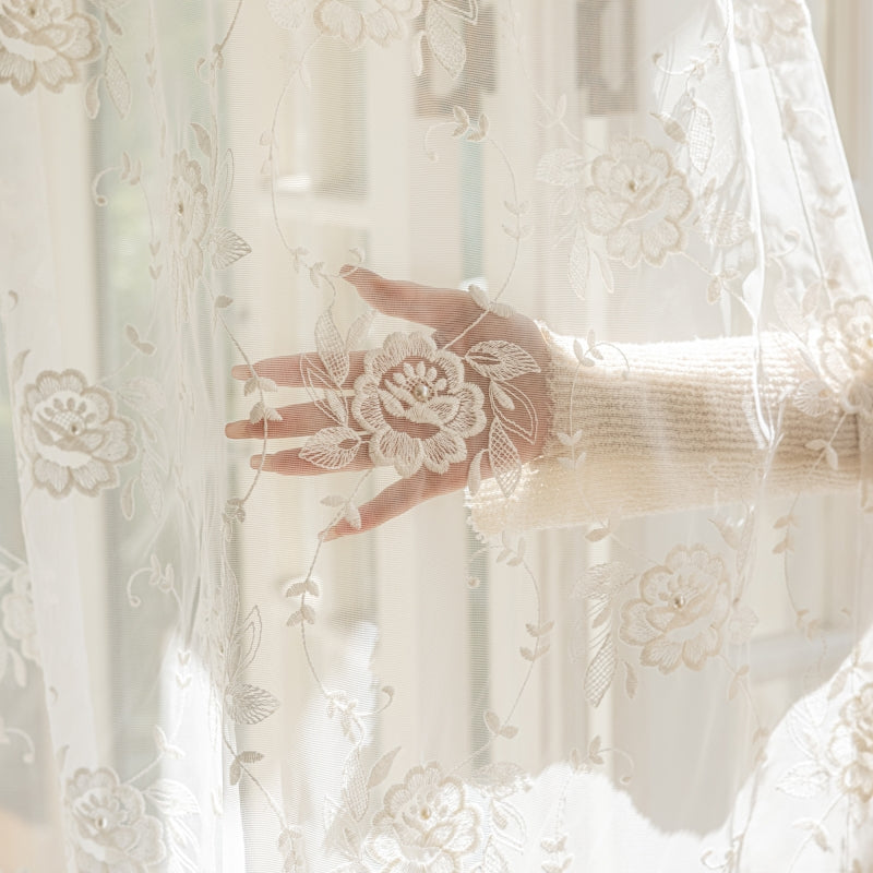 a woman's hand is seen through a sheer curtain