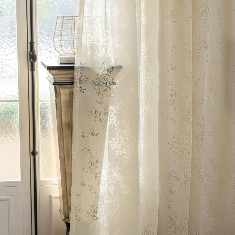 a window with a white curtain and a basket on top of it