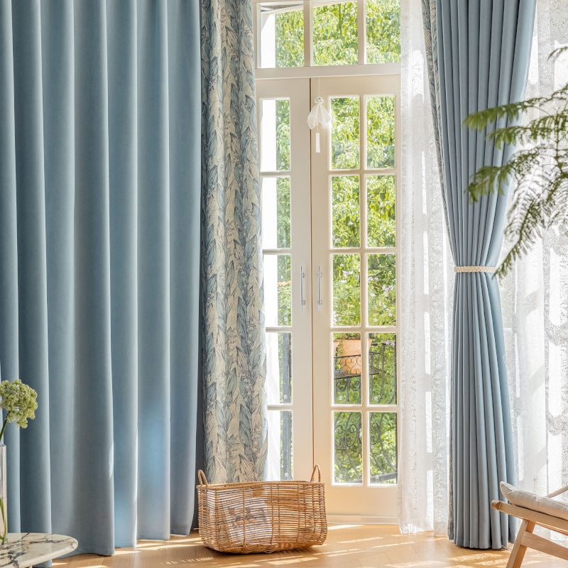 a living room with blue curtains and a basket on the floor