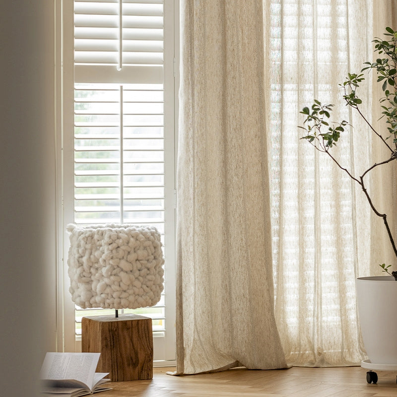 a white vase with a plant in it next to a window