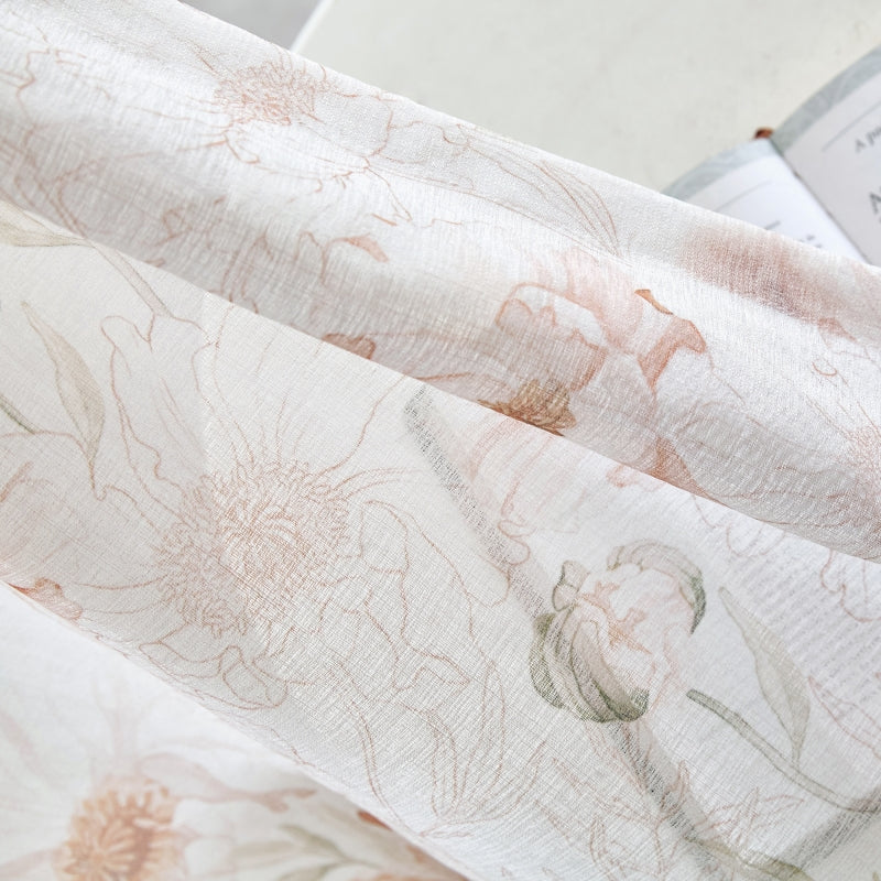 a close up of a flowered fabric with a book in the background