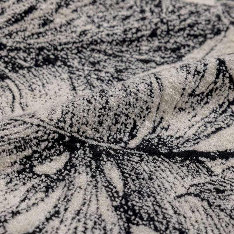 a black and white rug with a leaf pattern