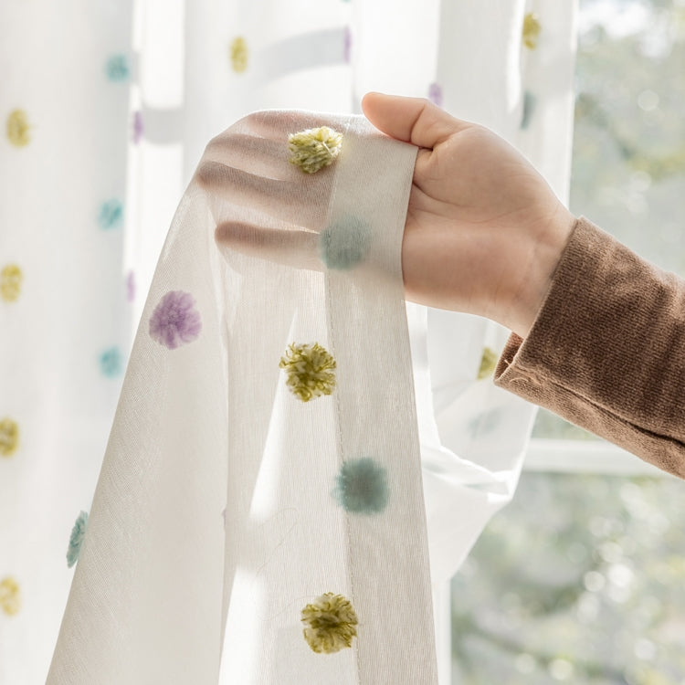 a person holding a curtain with a flower on it