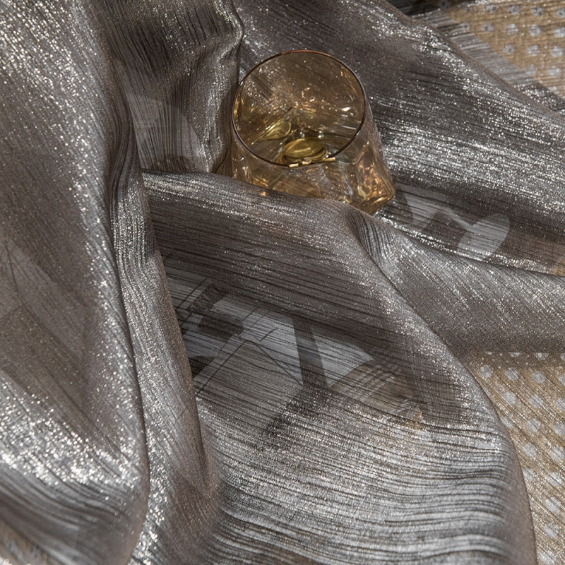 a glass sitting on top of a silver cloth