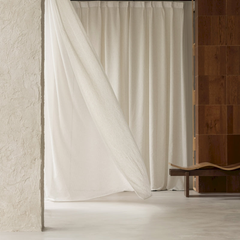 a room with a white curtain and a chair