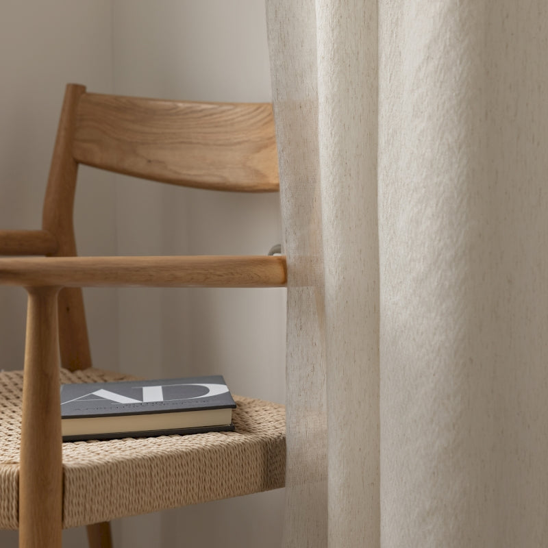 a book sitting on a chair next to a window