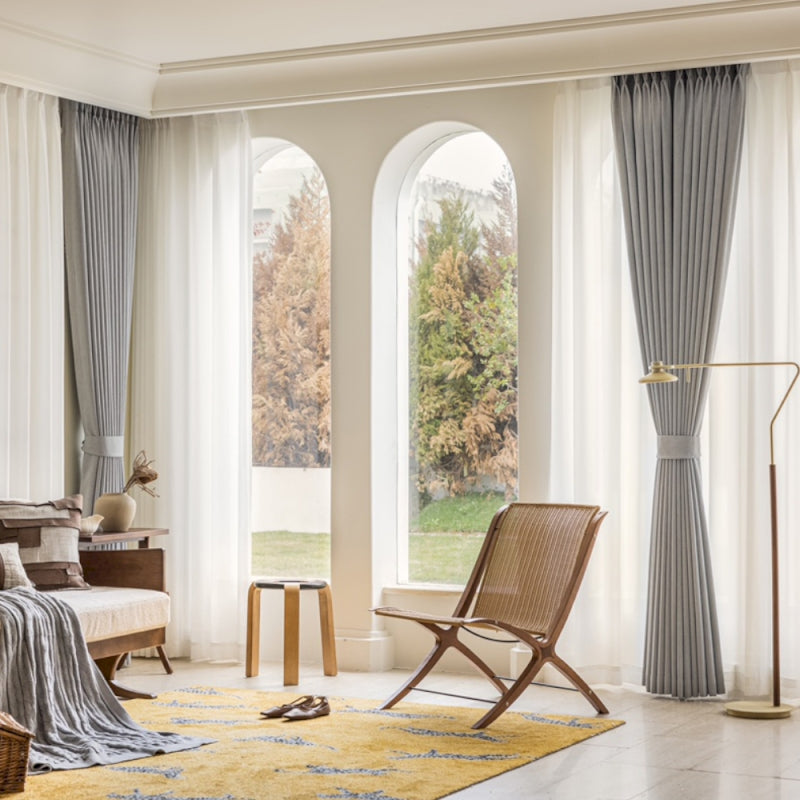a living room filled with furniture and large windows