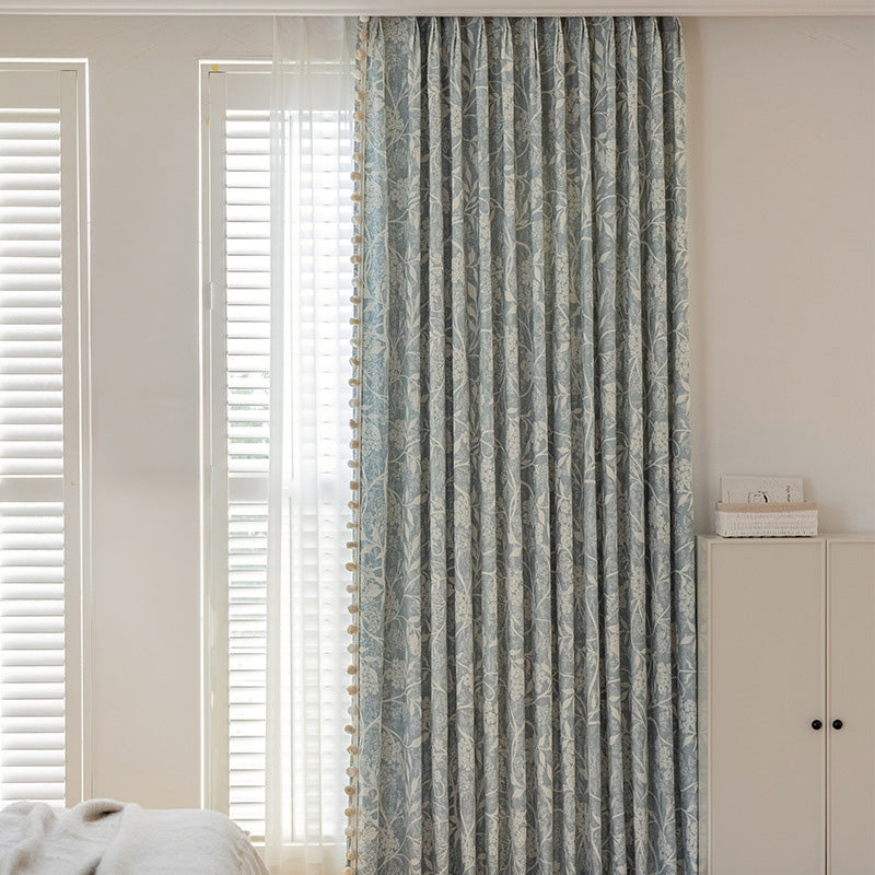 a bedroom with a bed and a window covered in curtains