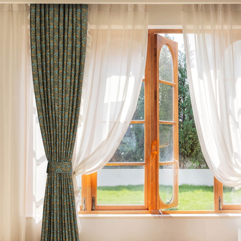 a window with a curtain and a chair in front of it
