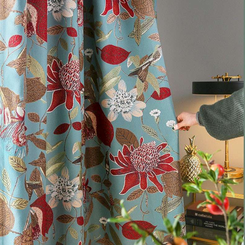 a person is opening a curtain with a flower pattern