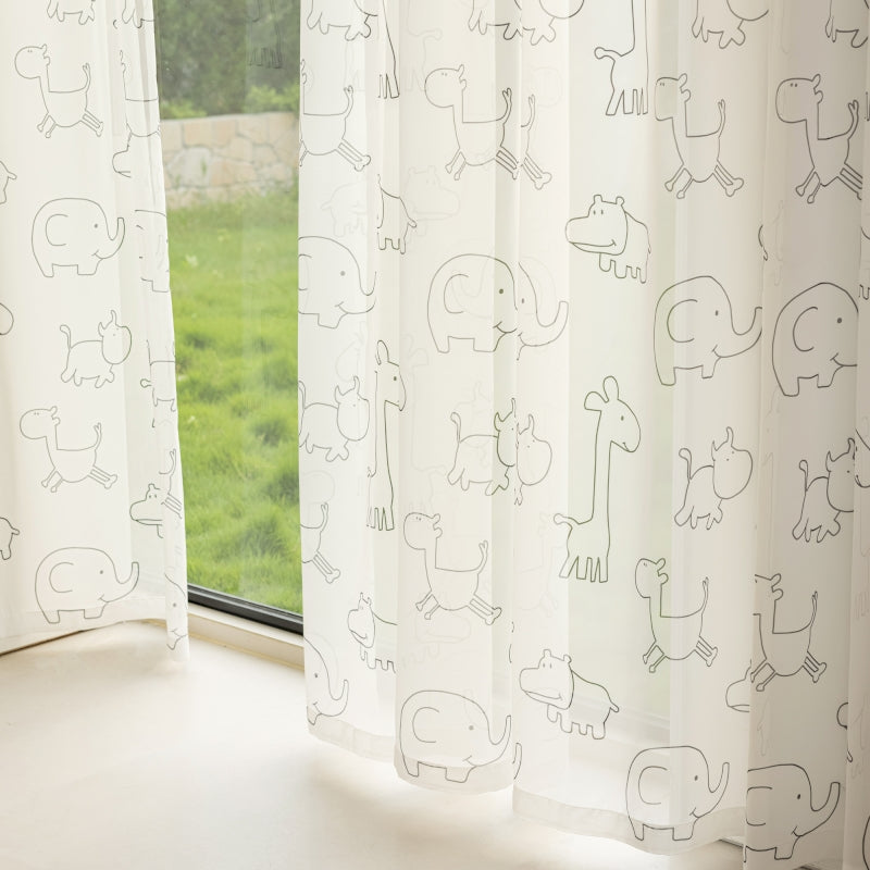 a window with a curtain that has drawings on it