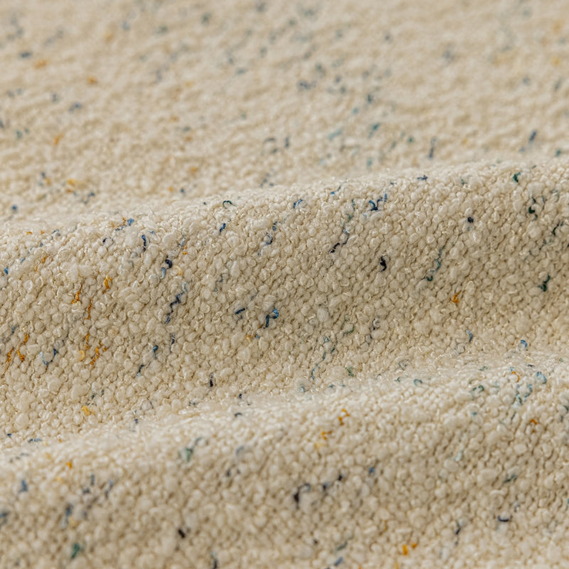 a close up of a white blanket with blue and yellow speckles