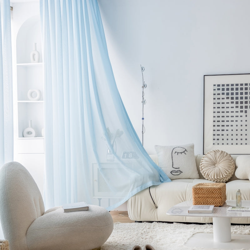 a living room with a white couch and blue drapes