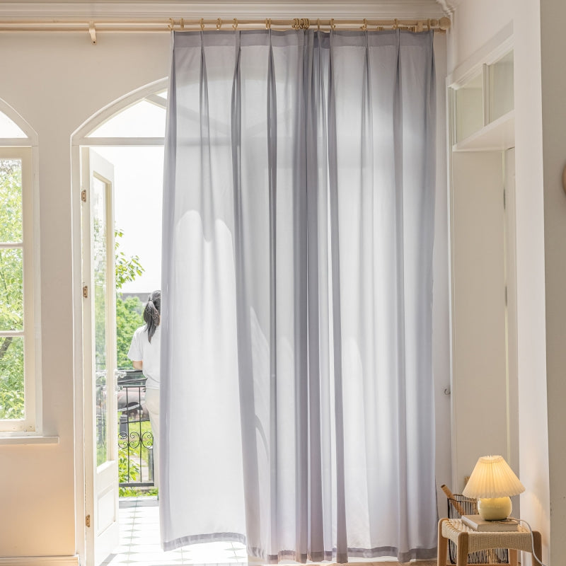 a living room with a large window and curtains