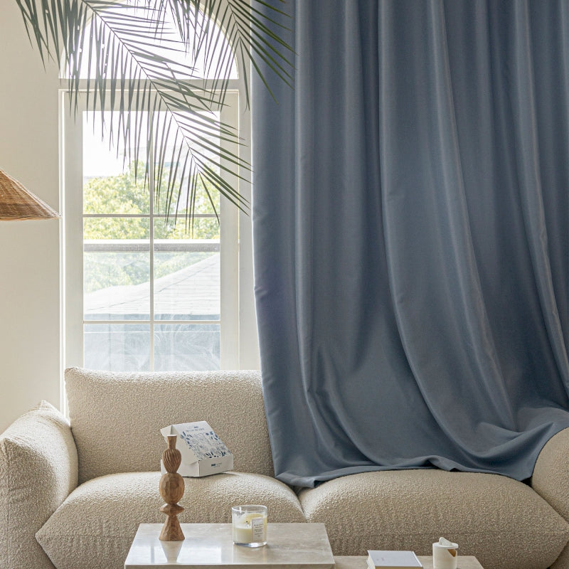 a living room with a white couch and a blue curtain