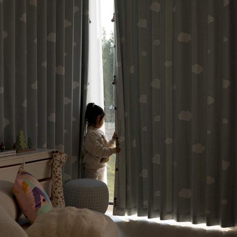 a little girl standing in front of a window