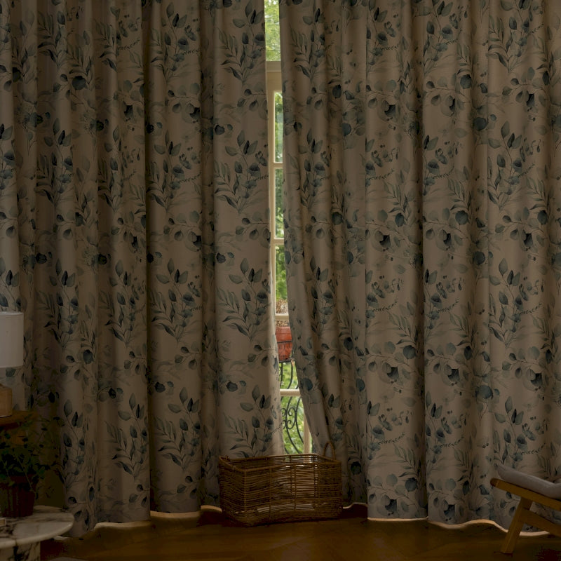 a living room with a large window covered in curtains